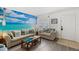 Coastal-themed living room with comfortable seating and a bright ocean mural at 1531 Placida Rd # 201, Englewood, FL 34223