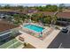 Aerial view of sparkling pool with lounge chairs, set in community with mature landscaping and shuffleboard courts at 1531 Placida Rd # 201, Englewood, FL 34223
