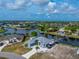 Stunning aerial view of waterfront property with lush landscaping and private boat dock, ideal for luxury living at 15674 Applewhite Cir, Port Charlotte, FL 33981