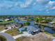 Aerial view of a waterfront home, complete with a private dock, expansive driveway, and easy access to the main waterways at 15674 Applewhite Cir, Port Charlotte, FL 33981