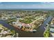 Aerial view of waterfront property with boat access and lush landscaping in a serene, coastal community setting at 15674 Applewhite Cir, Port Charlotte, FL 33981