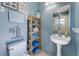Bathroom with pedestal sink, decorative shelving, and nautical-themed decor at 15674 Applewhite Cir, Port Charlotte, FL 33981