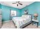 Bedroom with tile flooring, blue walls, ceiling fan, and matching grey dresser and side table at 15674 Applewhite Cir, Port Charlotte, FL 33981