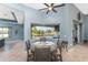 Bright breakfast nook features a round wood table, a ceiling fan, and a view of the lanai and canal at 15674 Applewhite Cir, Port Charlotte, FL 33981