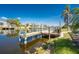 Waterfront home features a wooden dock with seating and a clear view of the canal under a bright blue sky at 15674 Applewhite Cir, Port Charlotte, FL 33981