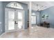 Elegant foyer featuring high ceilings, decorative columns, tile flooring and natural light creating a grand entrance at 15674 Applewhite Cir, Port Charlotte, FL 33981