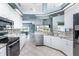 Well-equipped kitchen with white cabinets, stainless steel appliances, and a breakfast bar overlooking the living area at 15674 Applewhite Cir, Port Charlotte, FL 33981