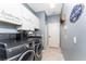 Laundry room features a modern washer and dryer, ample storage, and a playful laundry-themed decor at 15674 Applewhite Cir, Port Charlotte, FL 33981