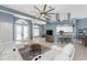 Inviting living room featuring tile floors, a modern ceiling fan, and an open layout leading to the kitchen at 15674 Applewhite Cir, Port Charlotte, FL 33981