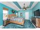 Inviting main bedroom with a tropical beachy theme, featuring a ceiling fan, and light blue walls and blue carpeting at 15674 Applewhite Cir, Port Charlotte, FL 33981