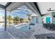 Relaxing screened-in pool area featuring a jacuzzi, ceiling fan, and waterfront view at 15674 Applewhite Cir, Port Charlotte, FL 33981