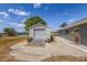 A spacious shed with a rolling door sits beside the house, complemented by a concrete ramp and rock landscaping at 15674 Applewhite Cir, Port Charlotte, FL 33981