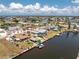 Aerial view of a waterfront home featuring a boat dock, tiki hut, and pool in a quiet residential neighborhood at 158 Morgan Se Ln, Port Charlotte, FL 33952