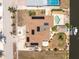 Overhead view of waterfront home with solar panels, tiki hut, boat dock, and pool in quiet neighborhood at 158 Morgan Se Ln, Port Charlotte, FL 33952