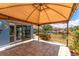 A covered patio with seating overlooks the landscaped lawn and waterfront at 158 Morgan Se Ln, Port Charlotte, FL 33952