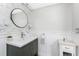 Updated bathroom features a modern vanity, round mirror, and tile accent wall at 158 Morgan Se Ln, Port Charlotte, FL 33952