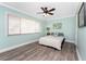 A calming bedroom features serene light blue walls, wood-look flooring, and bright natural light at 158 Morgan Se Ln, Port Charlotte, FL 33952