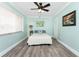 A calming bedroom features serene light blue walls, wood-look flooring, and bright natural light at 158 Morgan Se Ln, Port Charlotte, FL 33952