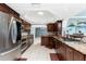 Elegant kitchen with stainless appliances, granite counters, cherry cabinets, and custom lighting at 158 Morgan Se Ln, Port Charlotte, FL 33952