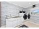 Laundry room featuring a white washer and dryer, a utility sink, and modern decor at 158 Morgan Se Ln, Port Charlotte, FL 33952