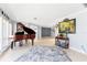 Open concept living room displaying a baby grand piano, tile flooring, and decorative accents at 158 Morgan Se Ln, Port Charlotte, FL 33952