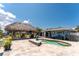 Inviting backyard with a kidney-shaped pool, tiki hut, and beautiful landscaping, ideal for relaxing at 158 Morgan Se Ln, Port Charlotte, FL 33952