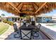 A shaded outdoor dining area under a tiki hut, complete with grill and patio furniture at 158 Morgan Se Ln, Port Charlotte, FL 33952