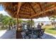 Shaded outdoor dining under a tiki hut, complete with patio furniture and waterfront views at 158 Morgan Se Ln, Port Charlotte, FL 33952