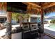 Grilling and dining area with a full kitchen, ceiling fan, and TV under a tiki hut at 158 Morgan Se Ln, Port Charlotte, FL 33952