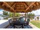 Outdoor dining area with a tiki hut, grill, and waterfront views, perfect for outdoor entertaining at 158 Morgan Se Ln, Port Charlotte, FL 33952