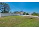 Home exterior with green grass, white fencing, and a large shade tree at 1585 Poinciana Rd, Venice, FL 34293