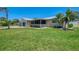 Exterior side view of the house showing the spacious, well-maintained lawn and screened-in porch at 1585 Poinciana Rd, Venice, FL 34293