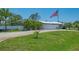 This home's front yard features green grass and a long driveway leading to the main house at 1585 Poinciana Rd, Venice, FL 34293