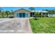Charming single-story home featuring a well-manicured lawn, metal roof, and a welcoming screened-in porch at 1585 Poinciana Rd, Venice, FL 34293