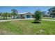 Single-story home featuring a metal roof, large front yard, mature landscaping, and a driveway at 1585 Poinciana Rd, Venice, FL 34293