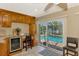 Kitchen area with custom cabinetry, granite countertops, and wine cooler that looks out to the pool at 1585 Poinciana Rd, Venice, FL 34293