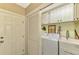 Functional laundry room with washer, dryer, storage cabinets, and utility sink at 1585 Poinciana Rd, Venice, FL 34293