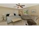 Cozy main bedroom featuring a sitting area, ceiling fan, and bright window at 1585 Poinciana Rd, Venice, FL 34293