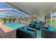 The covered patio features comfortable seating and a table, adjacent to the refreshing pool at 1585 Poinciana Rd, Venice, FL 34293