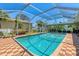 Enjoy swimming in this home's screened in outdoor pool with a brick-tile surround and tropical plants at 1585 Poinciana Rd, Venice, FL 34293