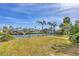 Lush waterfront backyard with mature palms, lush green grass and private dock at 17 Southwind Dr, Englewood, FL 34223