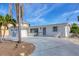 Inviting exterior of a charming home, with mature palms, well-kept yard, and private drive at 17 Southwind Dr, Englewood, FL 34223