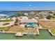 Aerial view of a waterfront home with a private pool, dock, and boat lift on a sunny day at 1915 Illinois Ave, Englewood, FL 34224