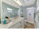 Bright bathroom featuring a large mirror, vanity, and updated walk-in shower at 1915 Illinois Ave, Englewood, FL 34224