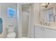 Simple bathroom with white tiled shower and floating vanity with updated fixtures at 1915 Illinois Ave, Englewood, FL 34224