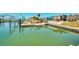 Waterfront canal with lush landscaping and dock, reflecting serene water views and clear skies at 1915 Illinois Ave, Englewood, FL 34224