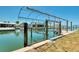 Waterfront view of boat lift and dock in a canal with lush green surroundings at 1915 Illinois Ave, Englewood, FL 34224