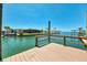 Wooden dock overlooking a tranquil canal with waterfront homes and clear blue skies in the background at 1915 Illinois Ave, Englewood, FL 34224