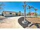 Charming home exterior featuring a circular driveway, palm trees, and a well-maintained lawn at 1915 Illinois Ave, Englewood, FL 34224