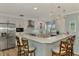 Modern kitchen with stainless steel appliances, white cabinetry, a breakfast bar, and stylish pendant lights creating an inviting space at 1915 Illinois Ave, Englewood, FL 34224